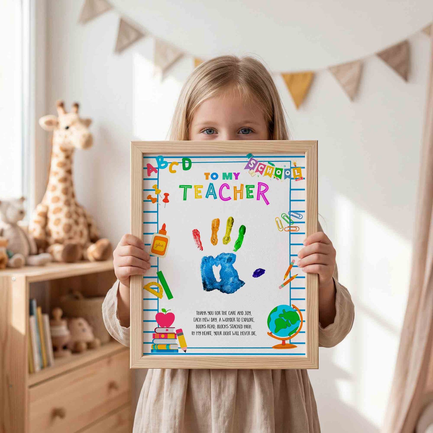 Child holding a framed artwork with 'To My Teacher' text in a room with toys and decorations.
