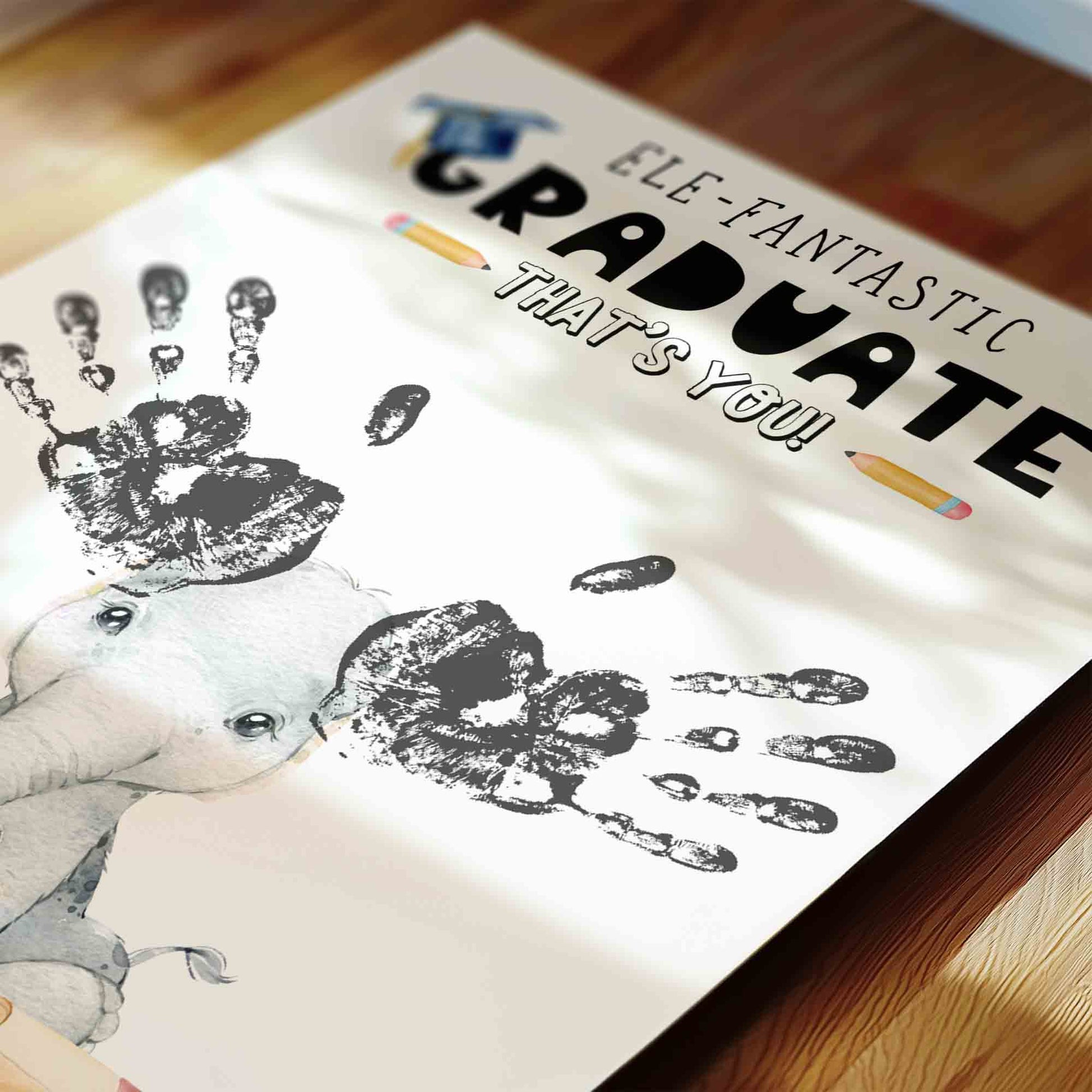 Graduation-themed towel with handprints and text on a wooden surface