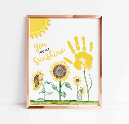 Framed artwork with sunflowers and handprint, featuring the text 'You are my sunshine'.