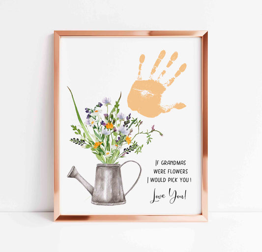 Framed artwork with a watering can, flowers, handprint, and text on a white background