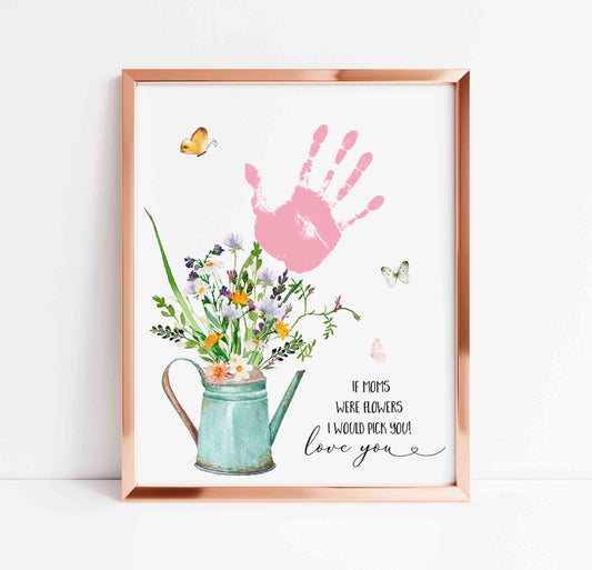 Framed artwork with a pink handprint, flowers, and a watering can on a white background.