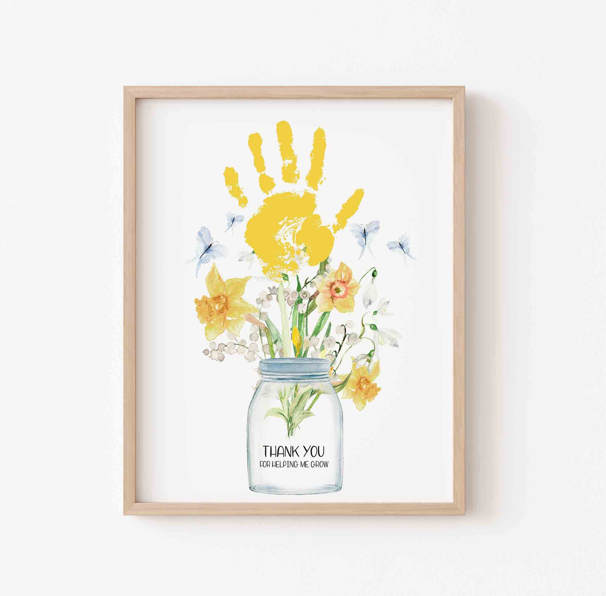 Framed artwork with a yellow handprint and flowers in a jar on a white background