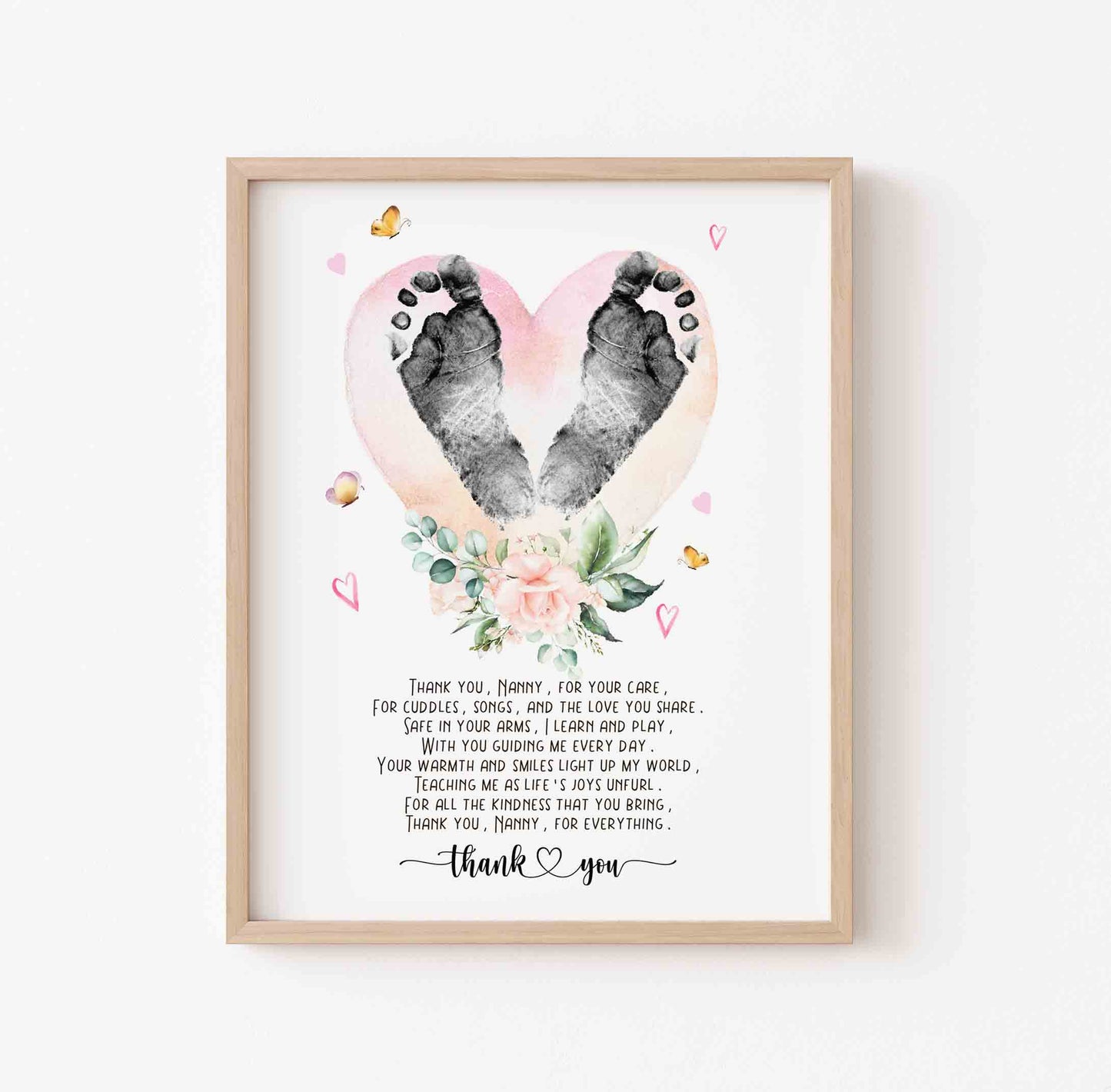 Framed artwork with footprints in a heart shape and floral design on a white background