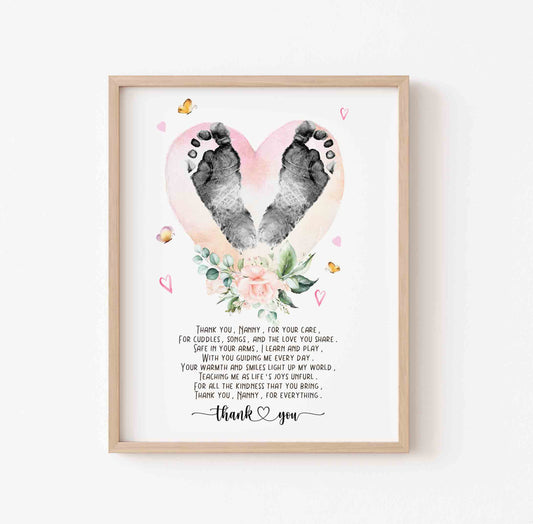 Framed artwork with footprints in a heart shape and floral design on a white background