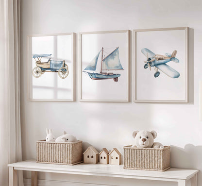 Set of three vintage-style nursery prints with a blue antique car, sailboat with sails, and light blue retro airplane on white backgrounds