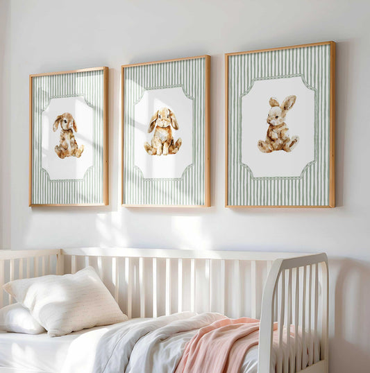 Three-piece watercolor nursery art set featuring adorable baby bunnies in different poses on white backgrounds with sage green stripe borders and decorative frames in natural wood