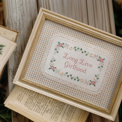 Long Live Girlhood nursery sign with cross stitch style lettering and floral trim