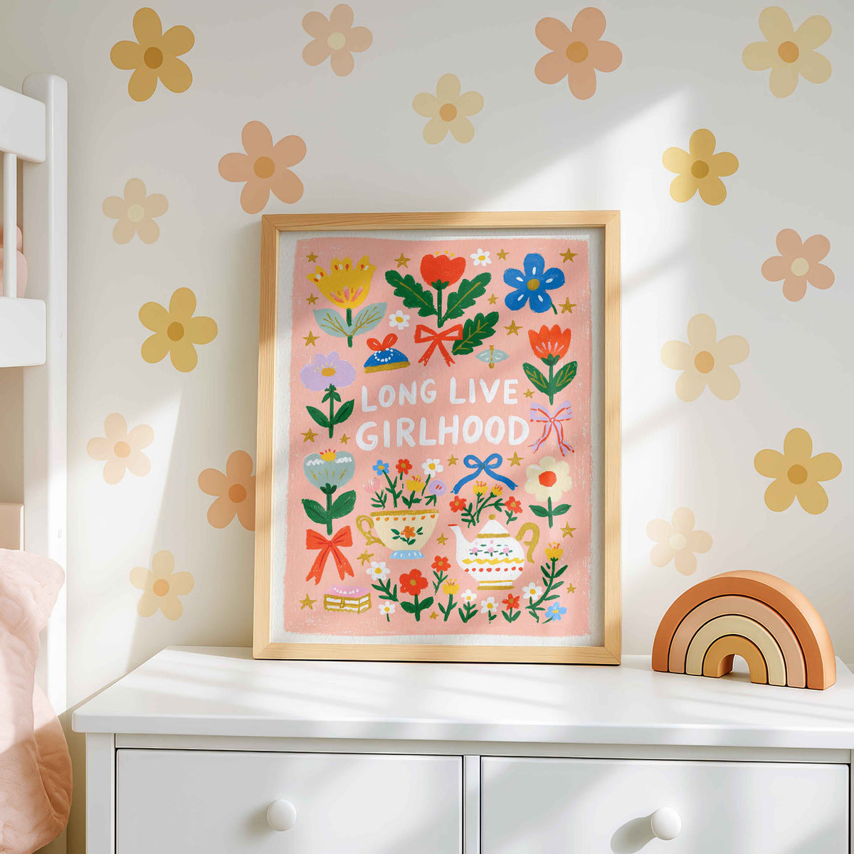 Retro wall art pairing a teapot with a gold handle and a flowered teacup with tulips, daisies and bows