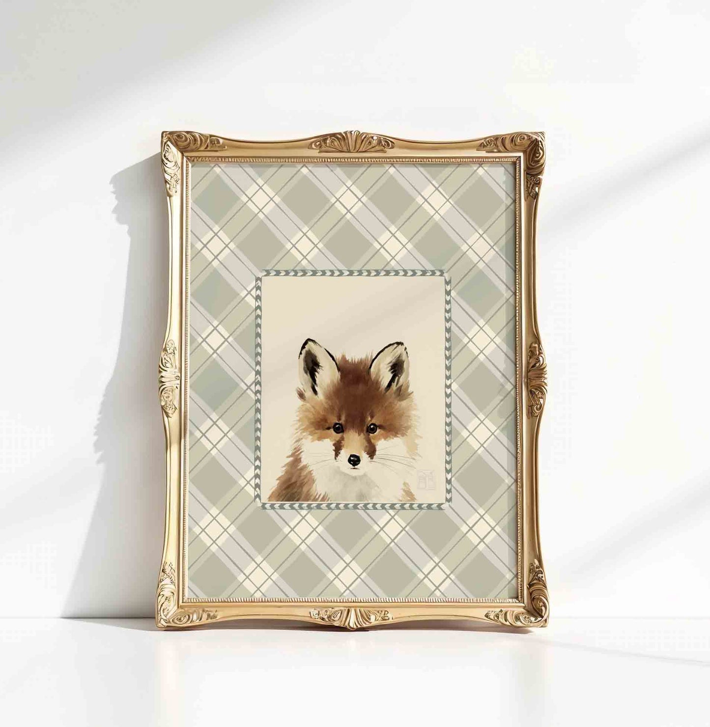 Watercolor fox portrait in an ornate gold frame styled for a woodland nursery room