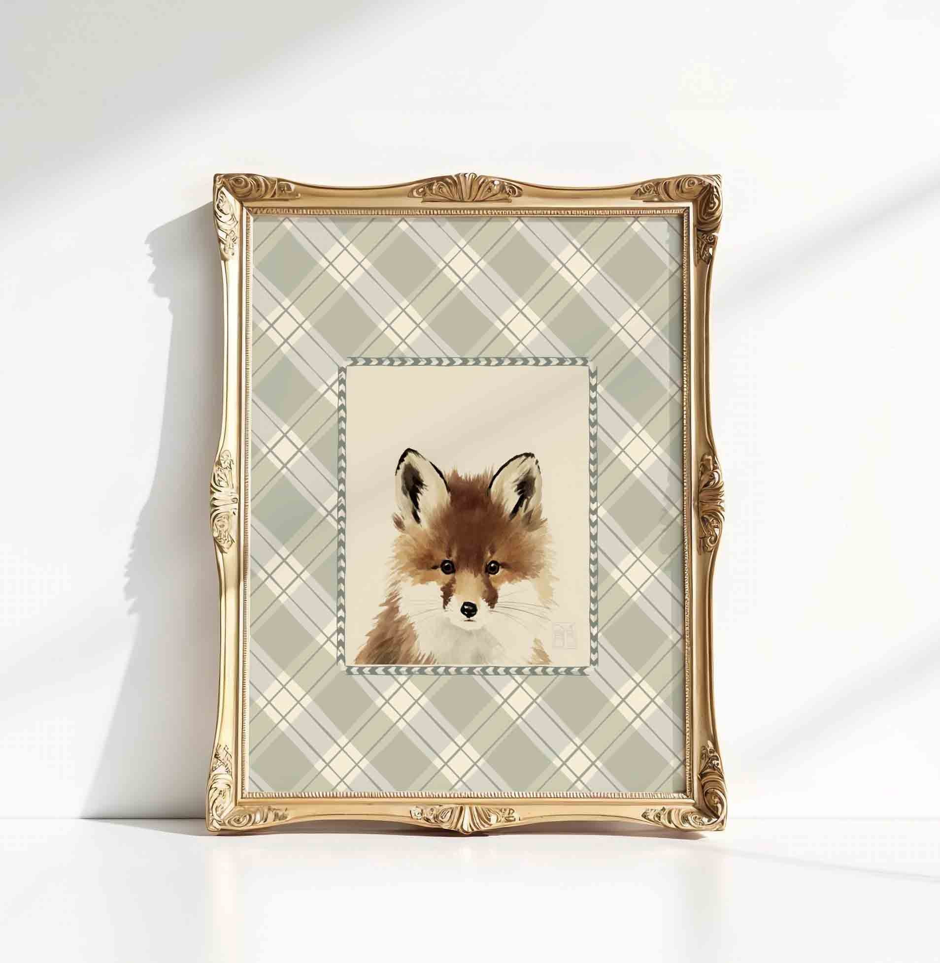 Watercolor fox portrait in an ornate gold frame styled for a woodland nursery room