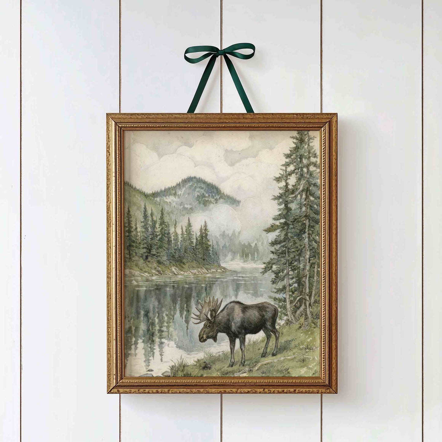 Watercolor moose by a mountain lake styled for a vintage woodland nursery room