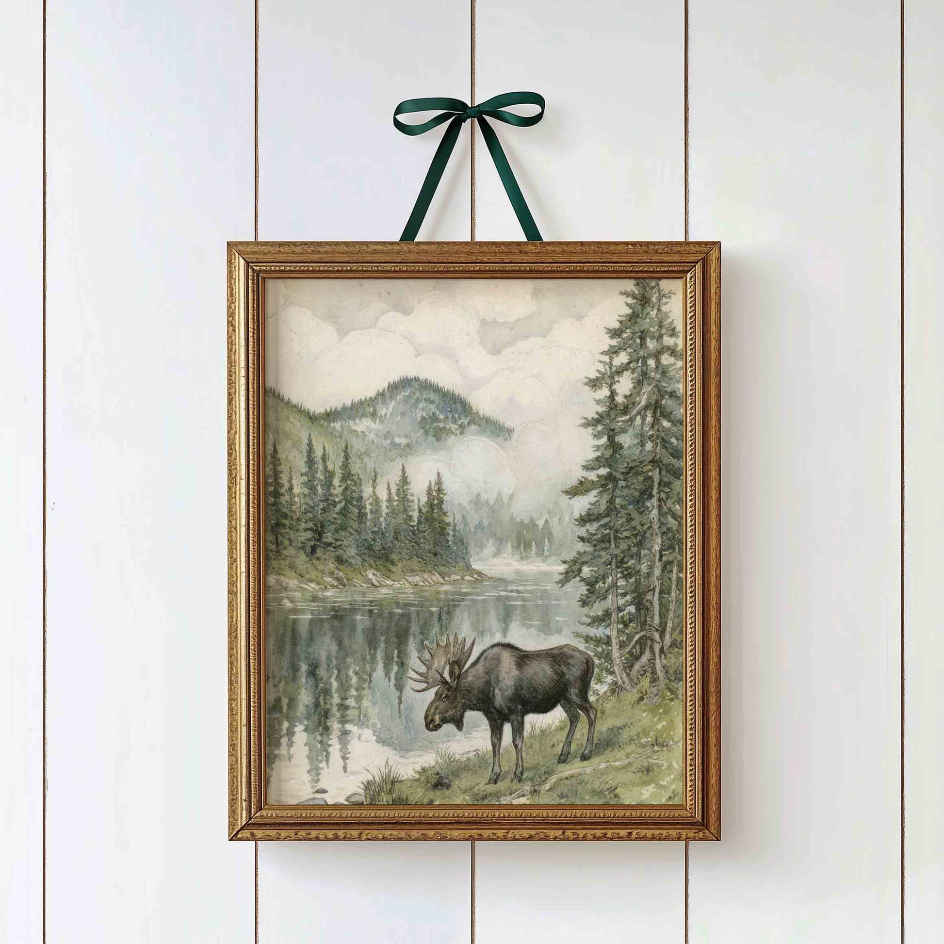 Watercolor moose by a mountain lake styled for a vintage woodland nursery room