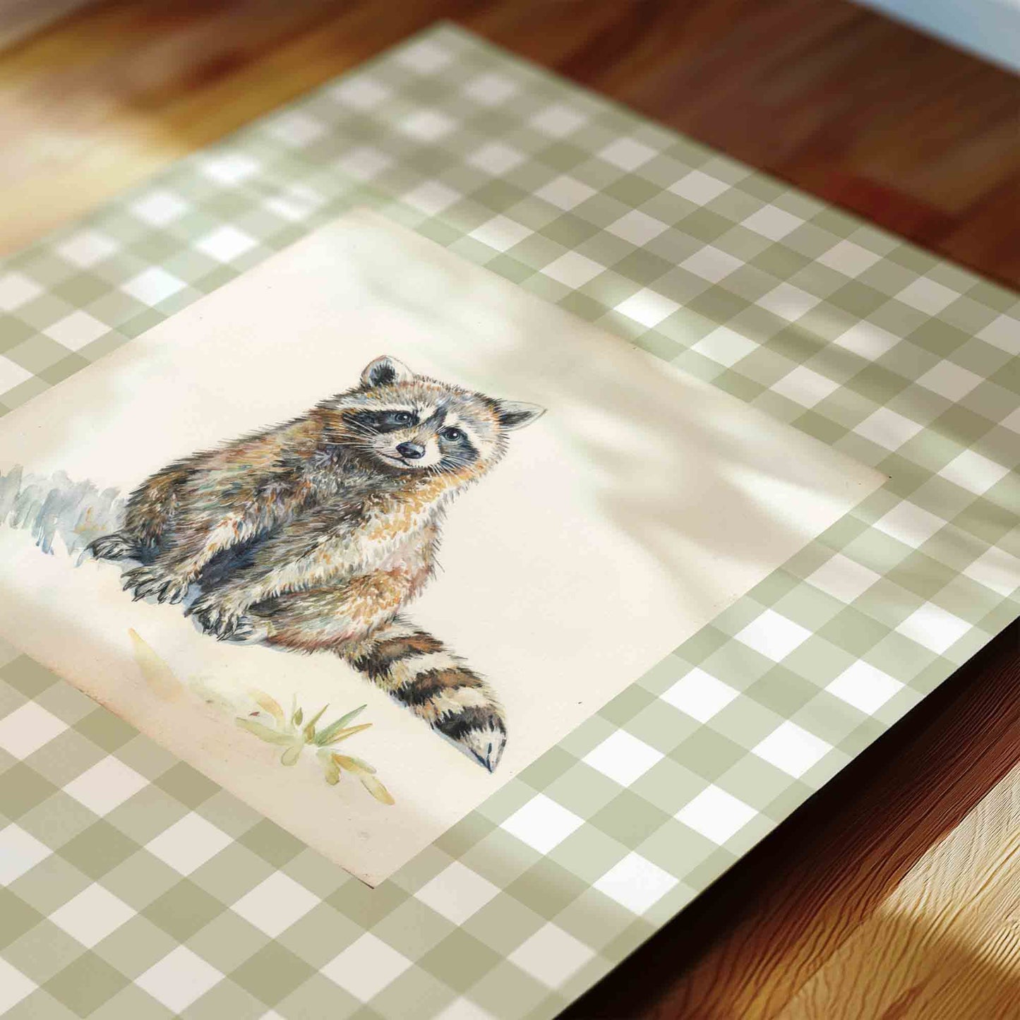 Watercolor raccoon print on gingham background styled for a woodland nursery room